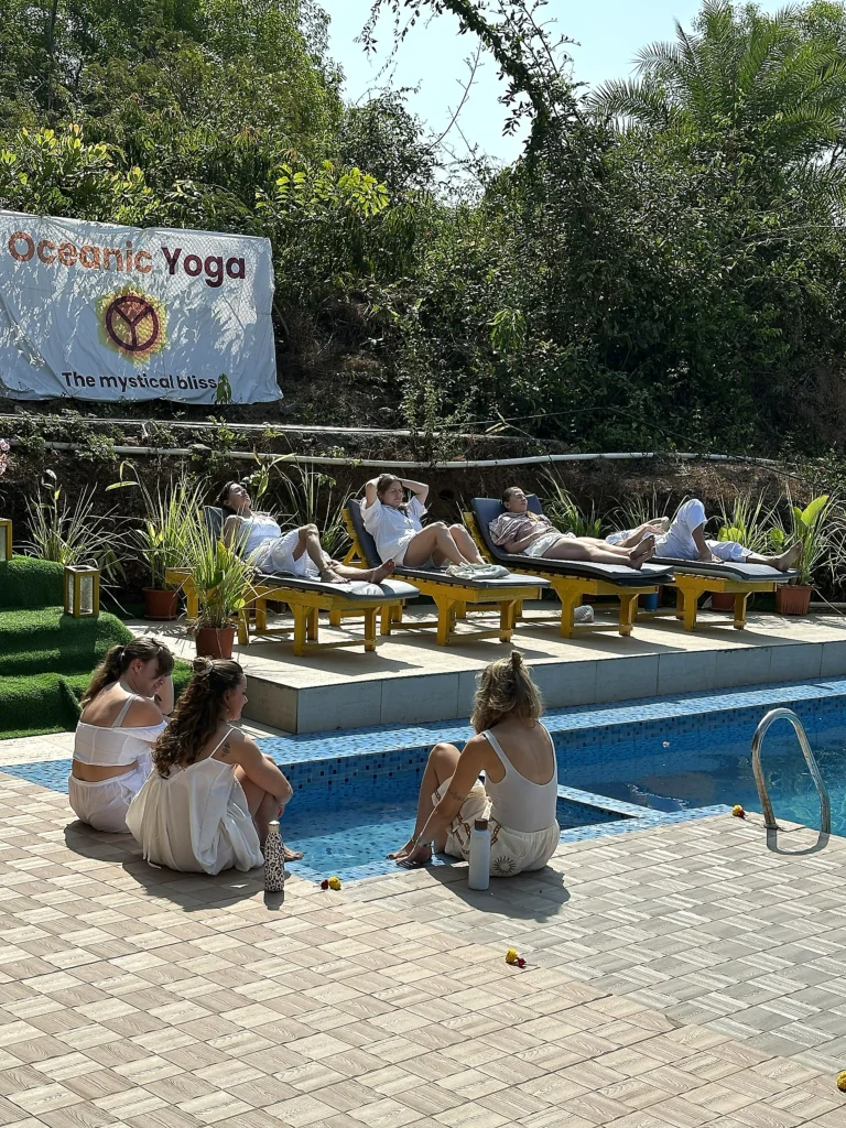 Guests relaxing on sun loungers and by the pool at Oceanic Yoga